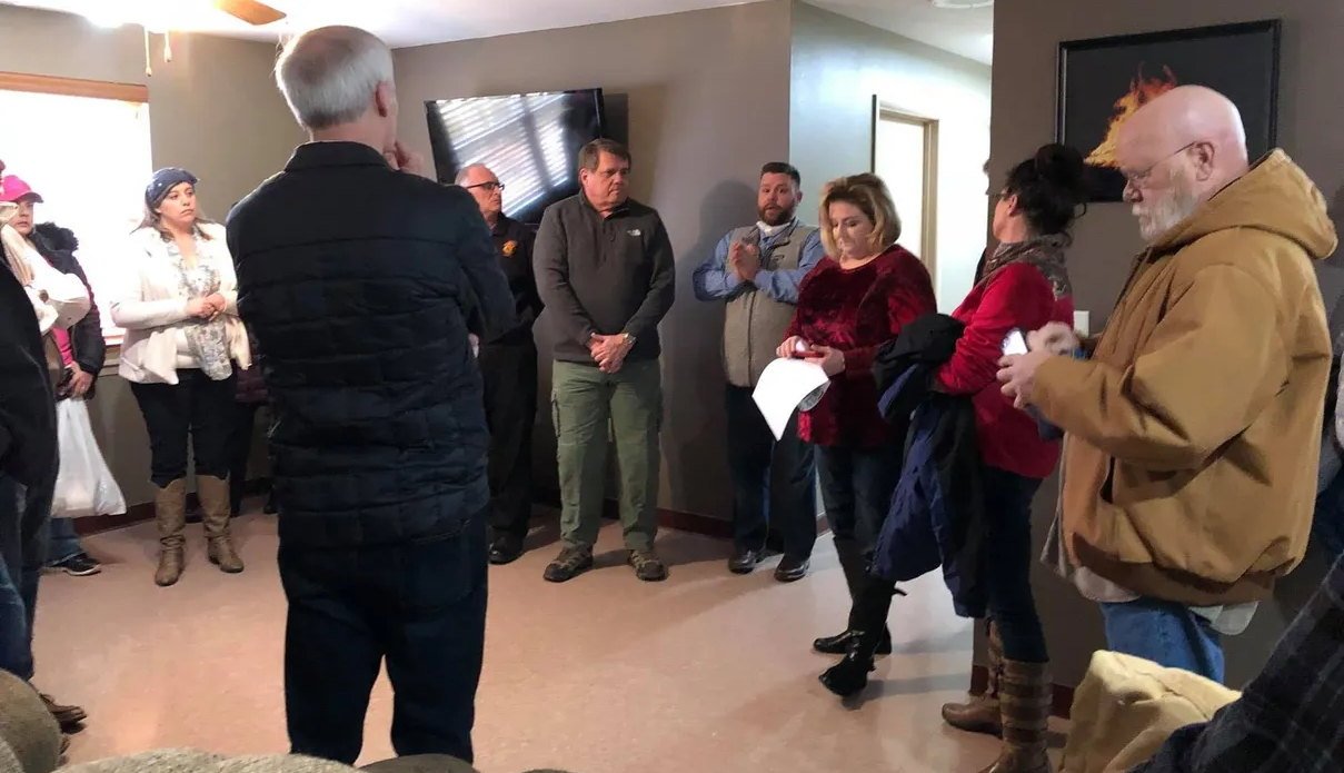 Residents and local officials gathered in a home for a briefing during the subterranean landfill fire response