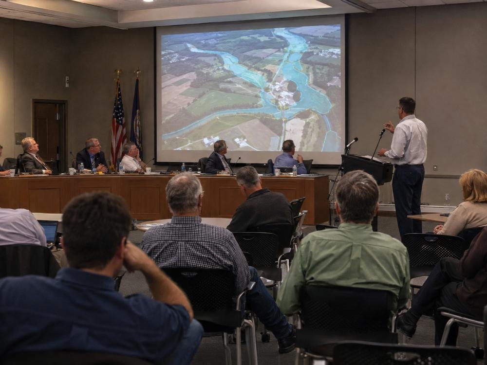Watershed mapping presented to a municipal board with residents seated in the room